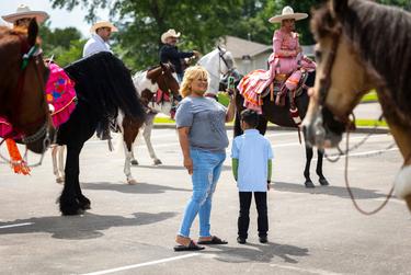 Leticia Solís se acerca al grupo de caballos después de que terminaron de montar en un desfile del Cinco de Mayo en la ciudad de Texas el 30 de abril de 2022.