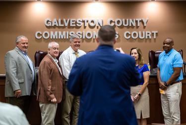 Los comisionados del condado de Galveston Darrell Apffel, Joe Giusti, el juez del condado Mark Henry y el comisionado Stephen Holmes posan para una foto grupal durante una reunión del Tribunal de Comisionados del Condado de Galveston en Galveston, TX, el lunes 4 de abril de 2022.