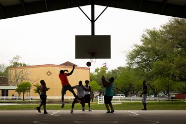 La gente juega baloncesto en Carver Park el 21 de abril de 2022 en la ciudad de Texas.