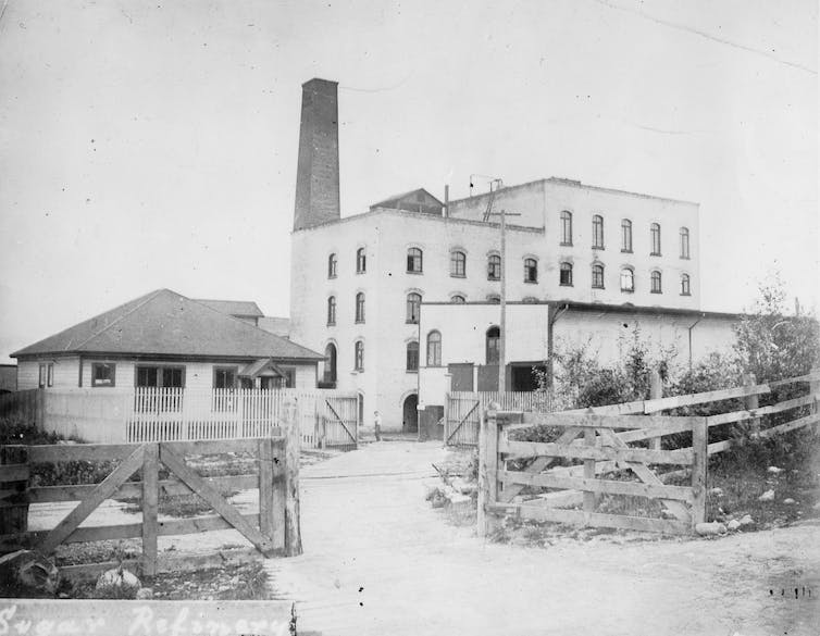 Una foto en blanco y negro de los antiguos edificios de la fábrica.